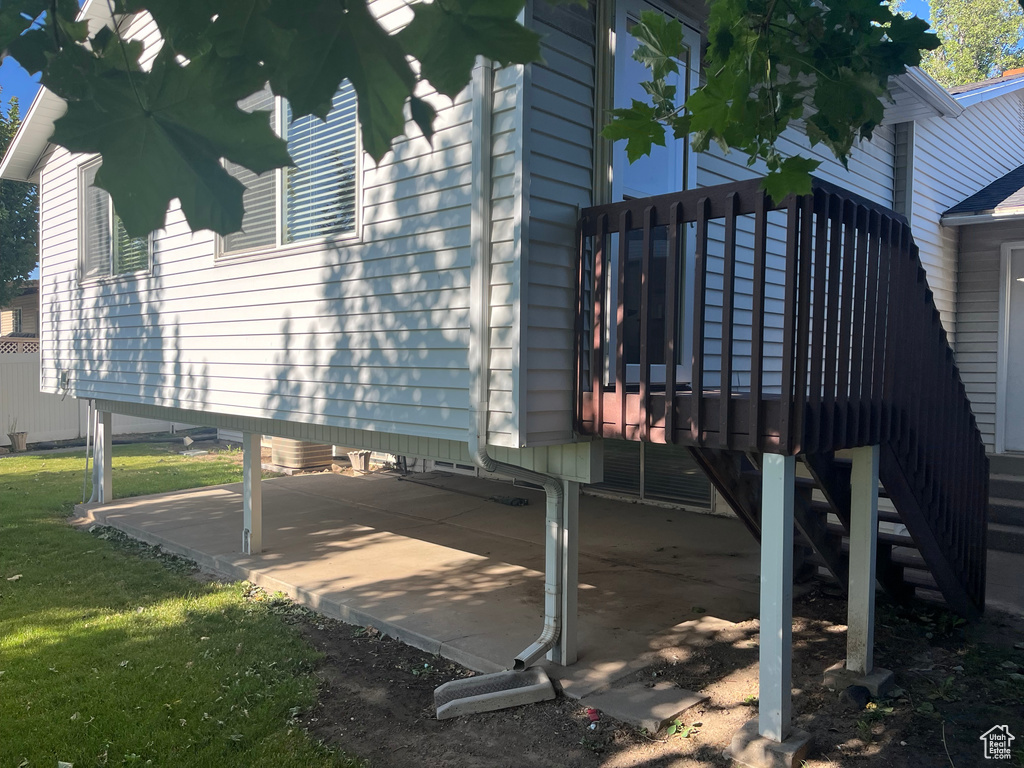 View of property exterior with a wooden deck and a yard
