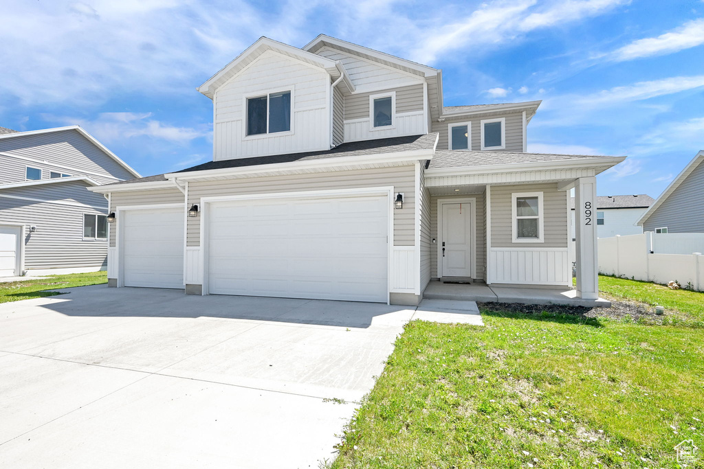 View of front of home featuring a porch, concrete driveway, board and batten siding, and an attached garage