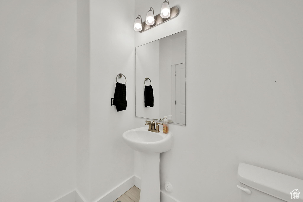 Half bathroom featuring toilet and baseboards