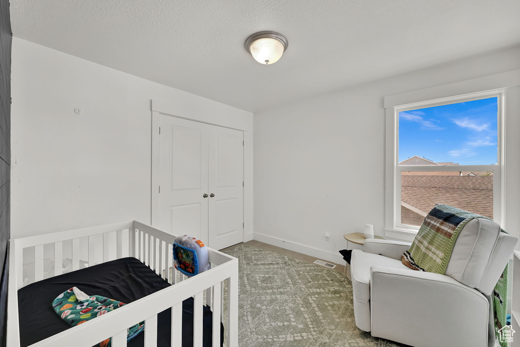 Carpeted bedroom featuring a closet and baseboards