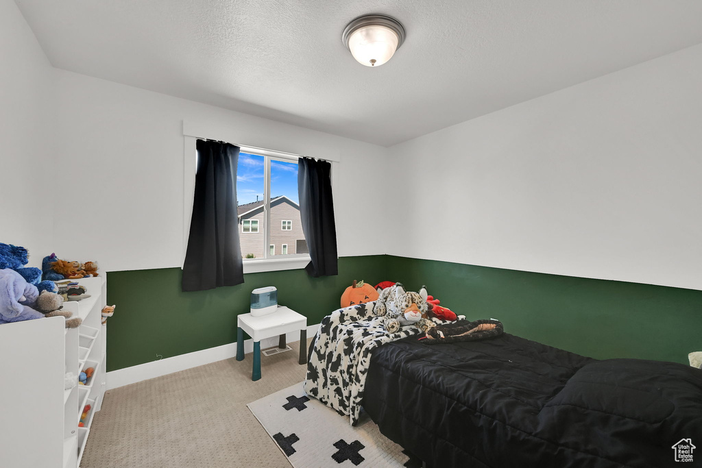 Bedroom featuring carpet and baseboards