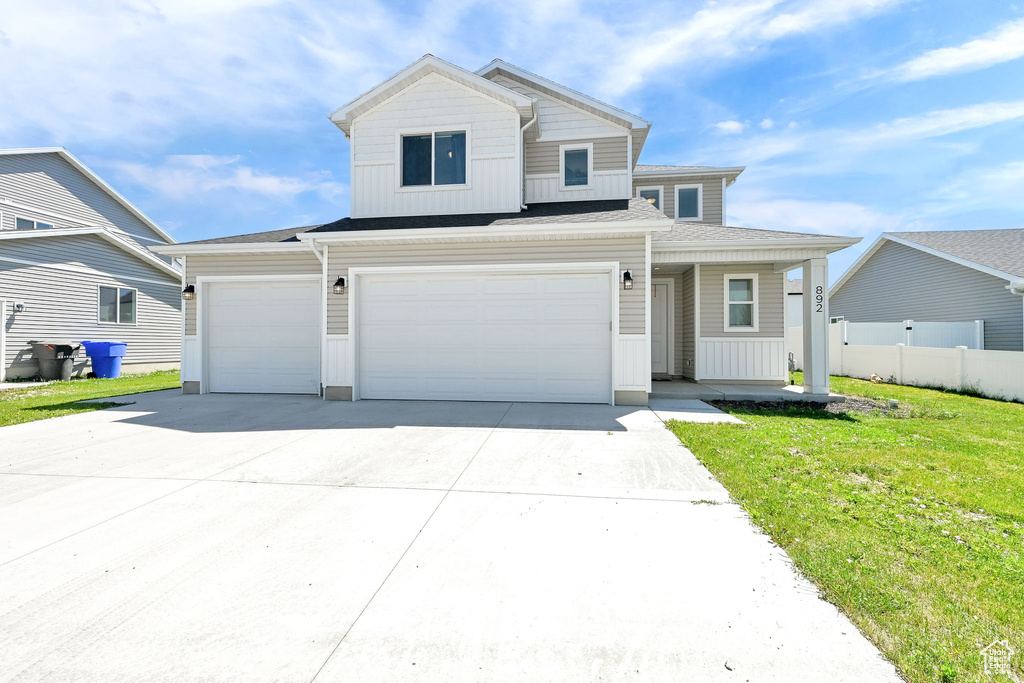 View of front of property featuring concrete driveway, board and batten siding, a garage, and an attached garage