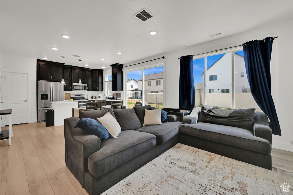 Living area featuring light wood-style floors and recessed lighting