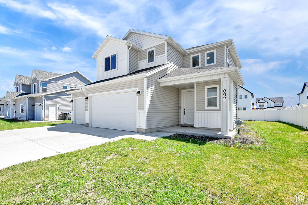 Multi unit property with driveway, a garage, a porch, and a residential view