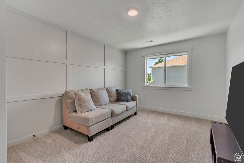 Living area featuring carpet flooring and a textured ceiling