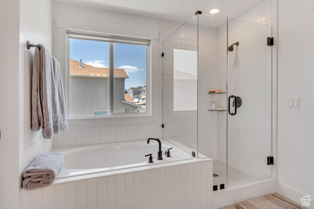 Bathroom featuring a bath and a shower stall