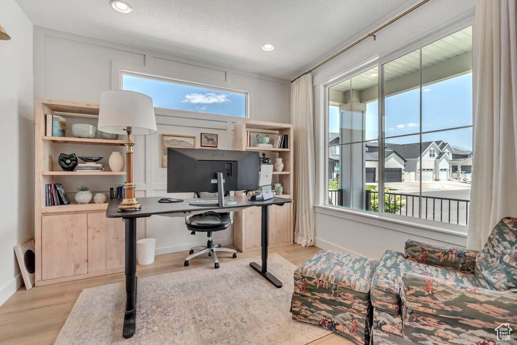 Office with wood finished floors and recessed lighting