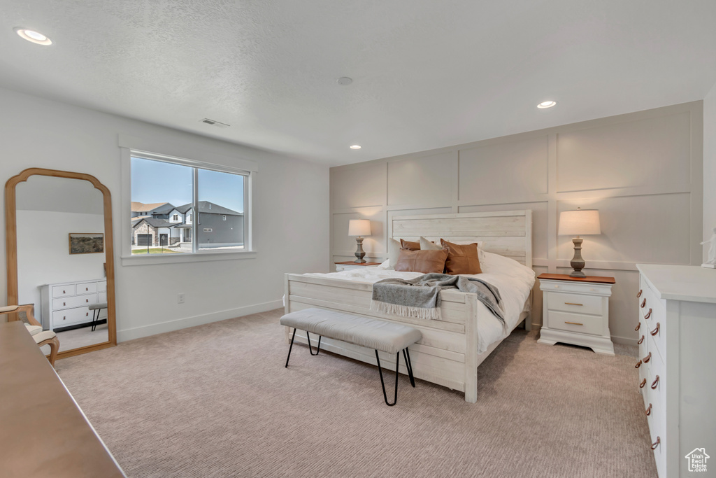 Bedroom with light colored carpet and recessed lighting