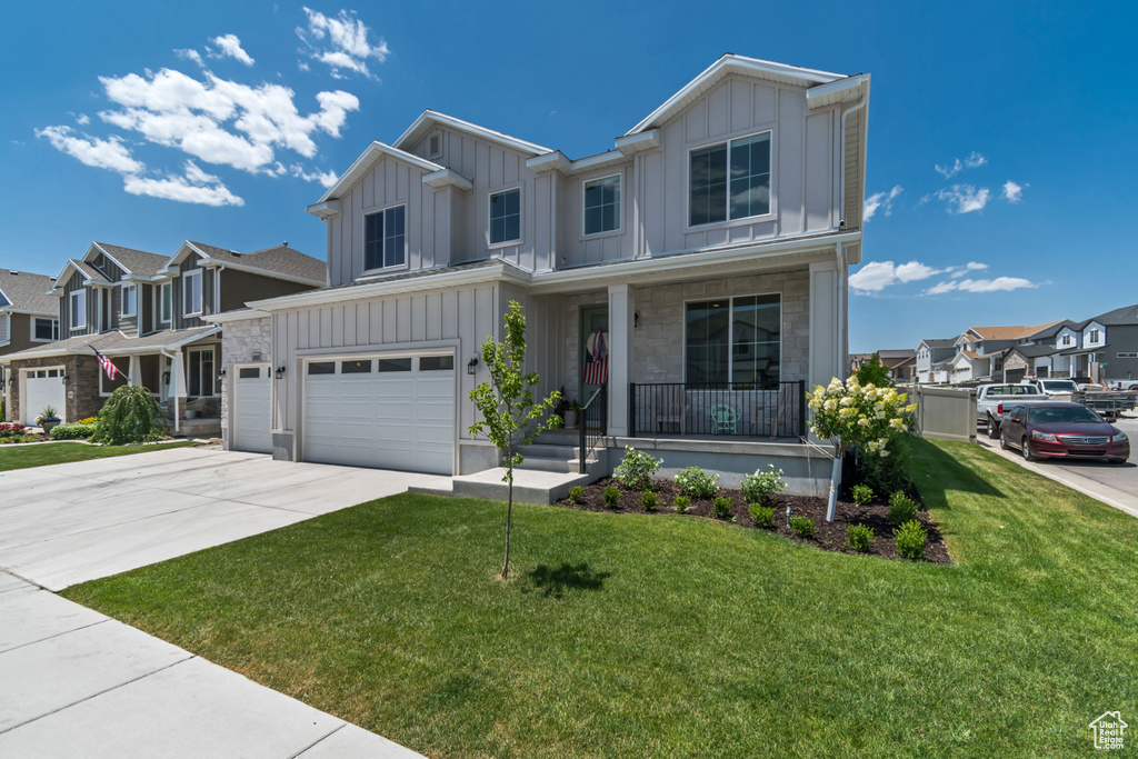 View of front of property with board and batten siding, covered porch, a residential view, a garage, and driveway