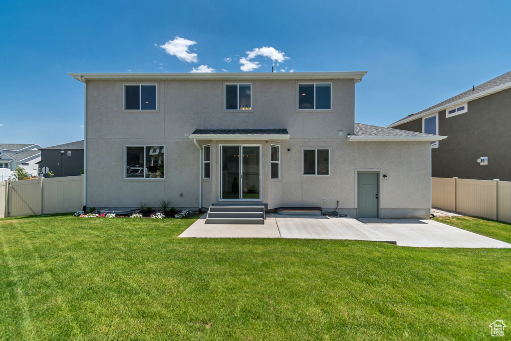 Rear view of property with stucco siding, a patio, a fenced backyard, and entry steps