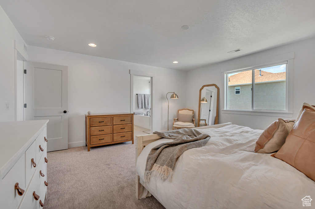 Bedroom with light carpet, recessed lighting, and connected bathroom