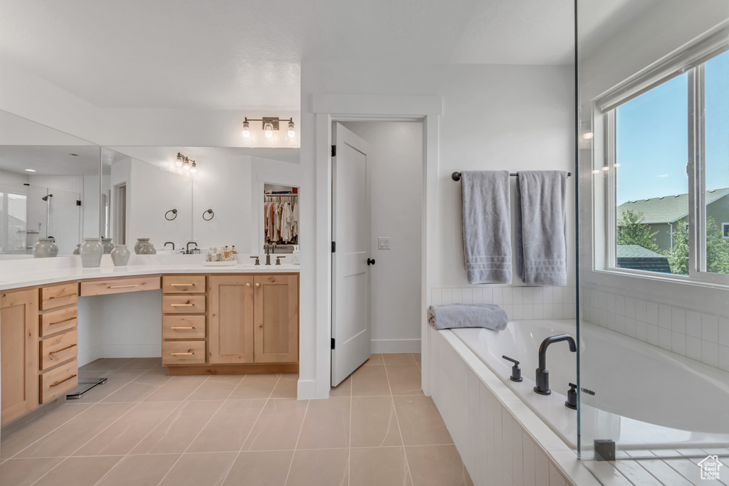 Full bathroom with vanity, a bath, tile patterned floors, and a shower with door