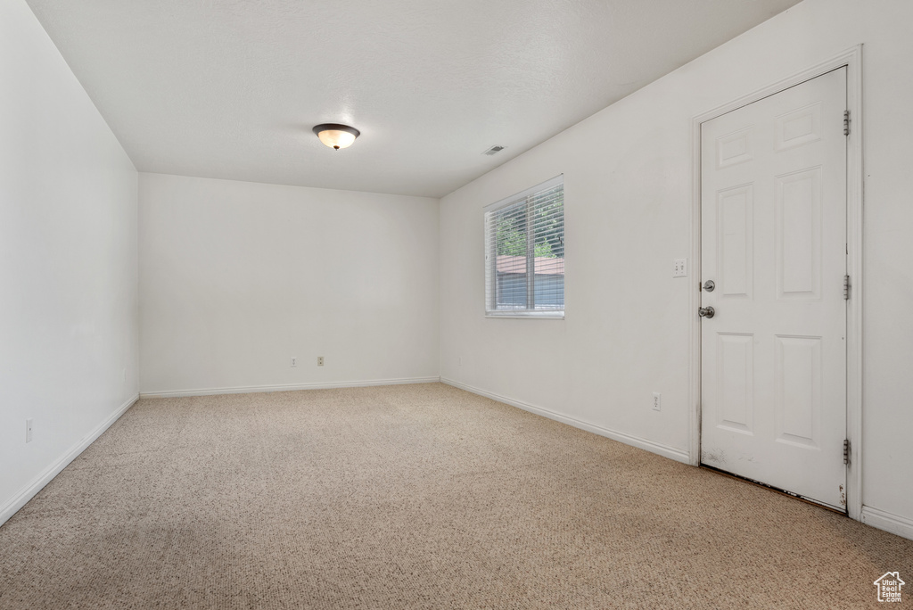 Carpeted spare room with baseboards