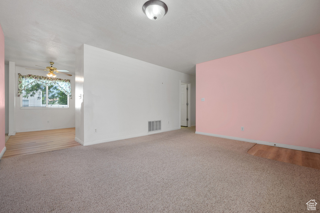 Spare room featuring a ceiling fan and carpet