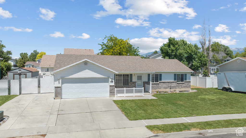 Ranch-style house featuring an attached garage, covered porch, concrete driveway, brick siding, and a gate
