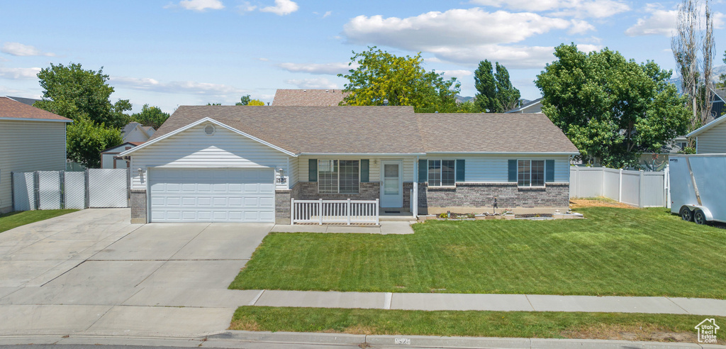 Single story home featuring a porch, a garage, driveway, brick siding, and roof with shingles