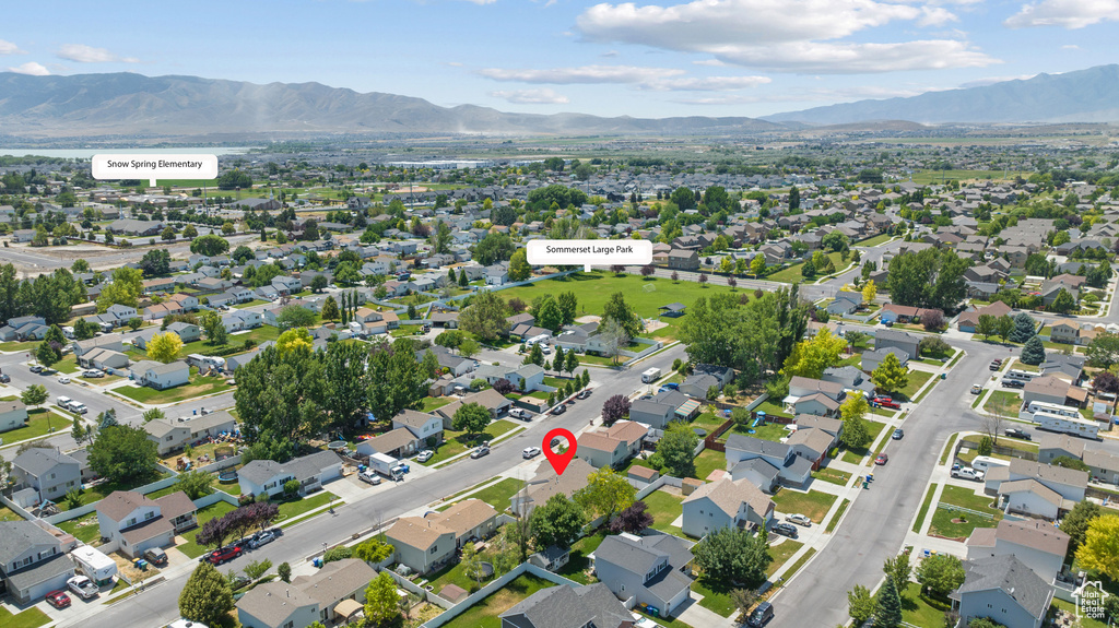Aerial view of property and surrounding area with mountains and nearby suburban area