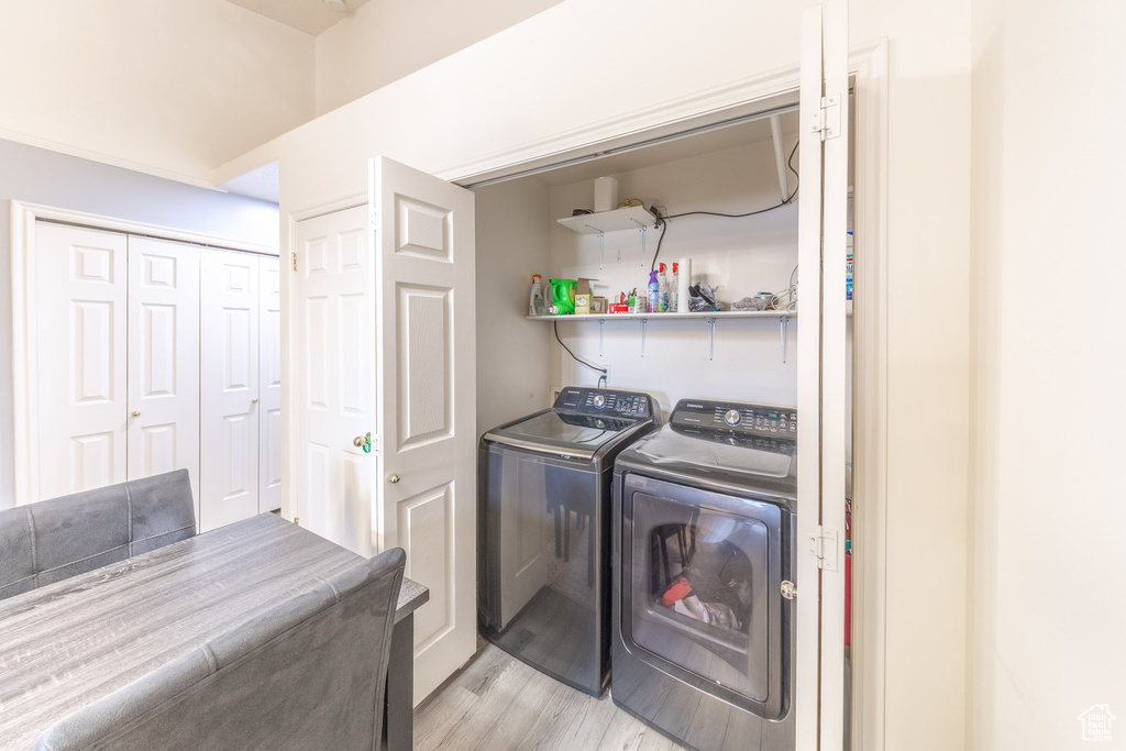 Washroom featuring washing machine and clothes dryer and light wood-style flooring