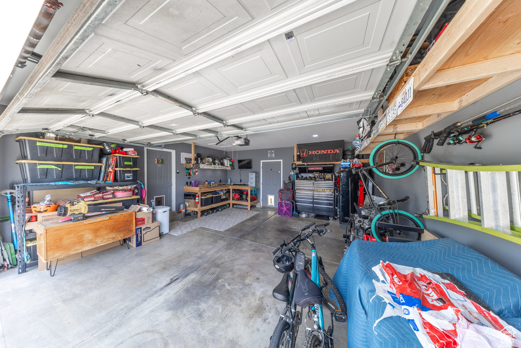 Garage featuring a garage door opener and a workshop area