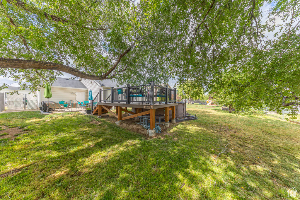 Fenced backyard featuring a wooden deck, a gate, and stairway