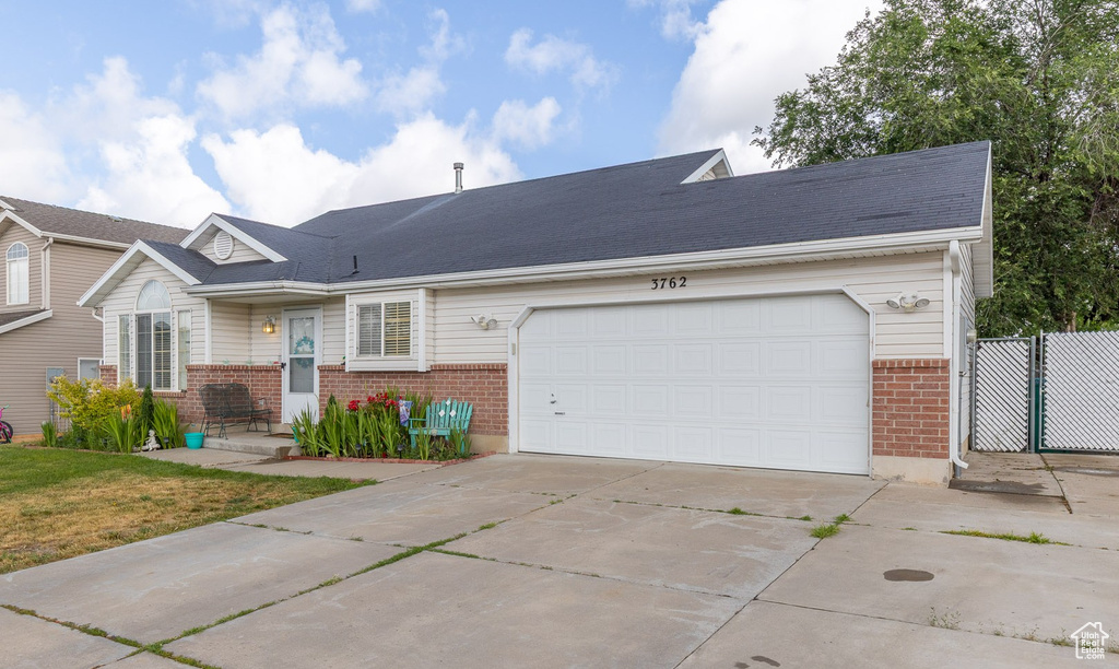 Ranch-style home with brick siding, concrete driveway, and a garage