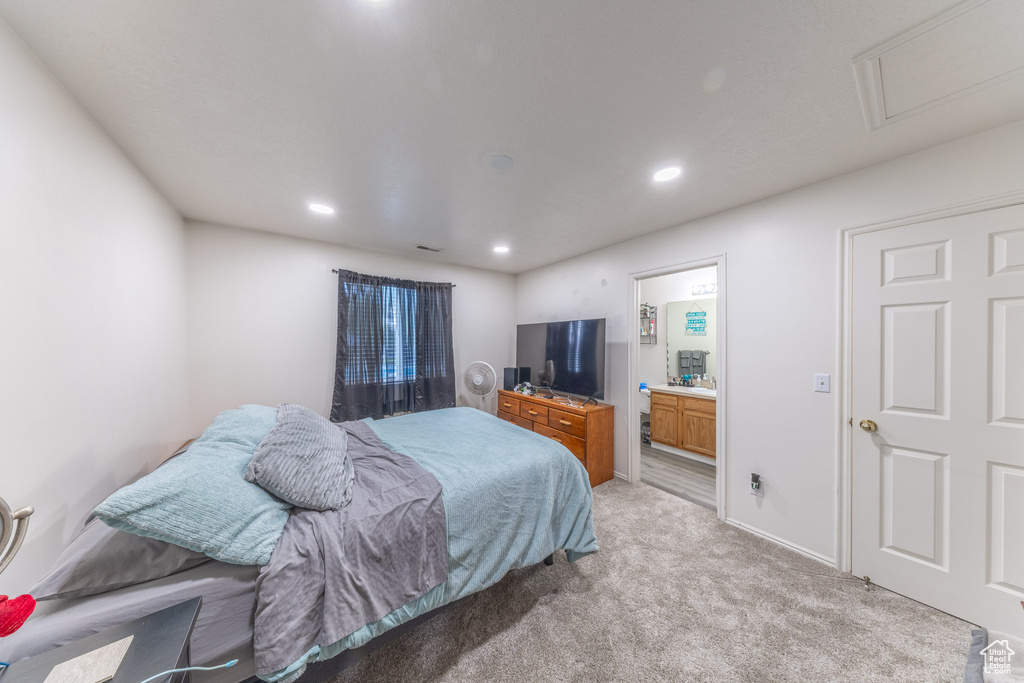 Bedroom with light carpet, recessed lighting, and ensuite bathroom