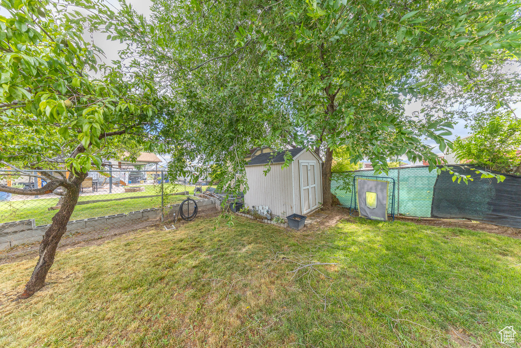 Fenced backyard featuring a storage shed