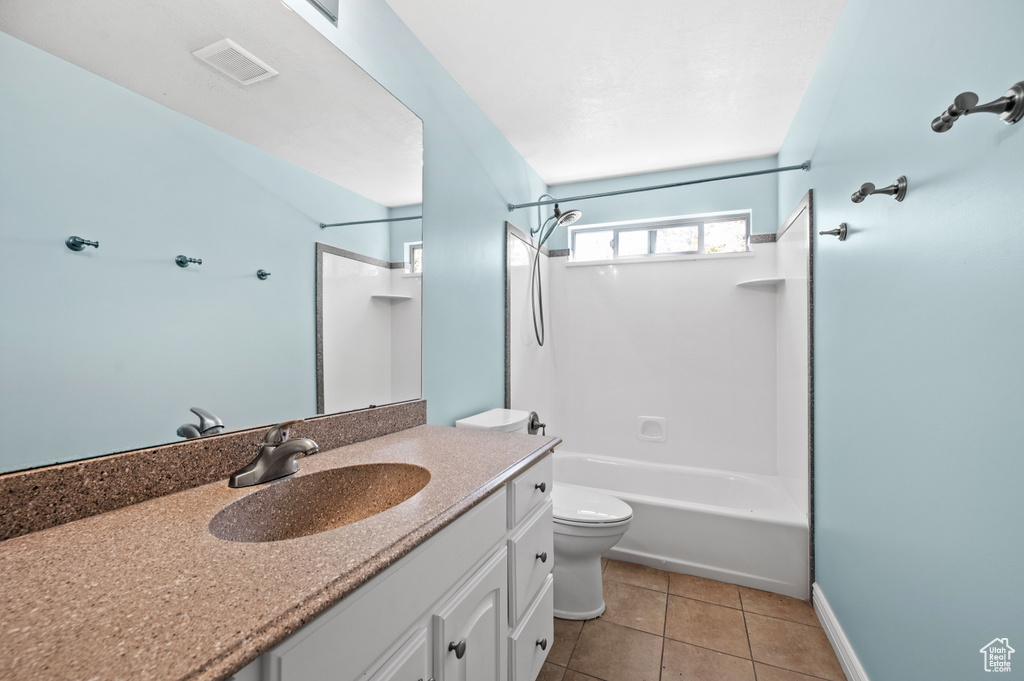 Bathroom featuring vanity, washtub / shower combination, and tile patterned flooring