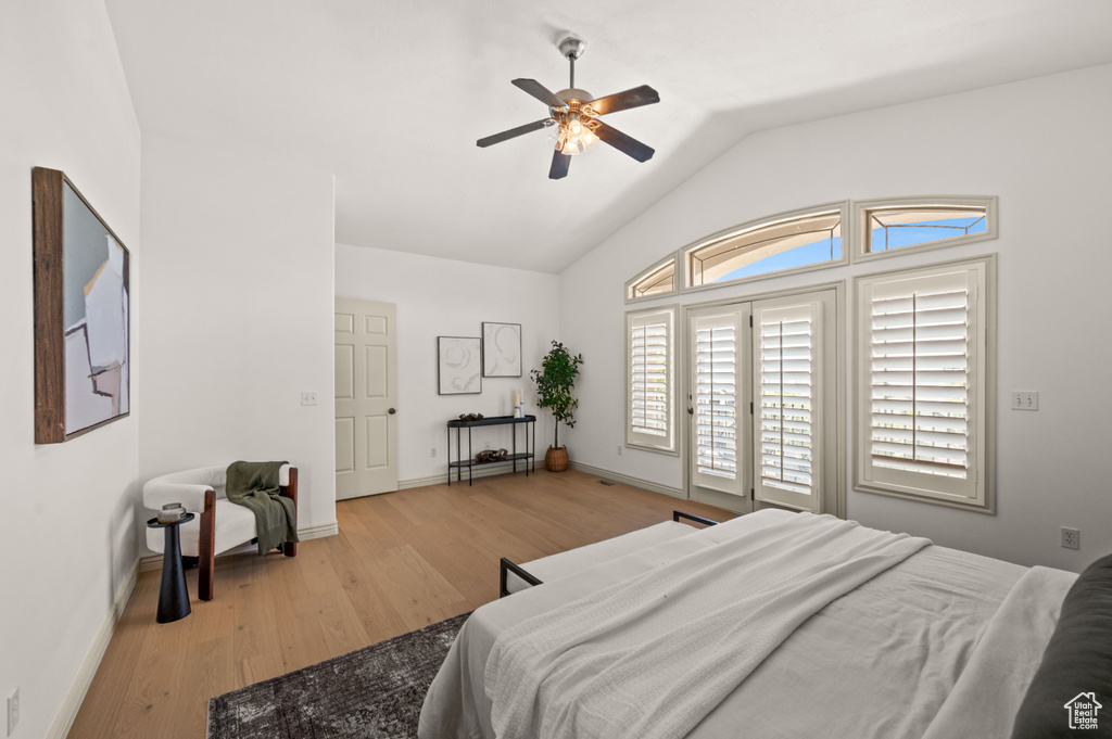 Bedroom featuring wood finished floors, vaulted ceiling, access to exterior, and ceiling fan