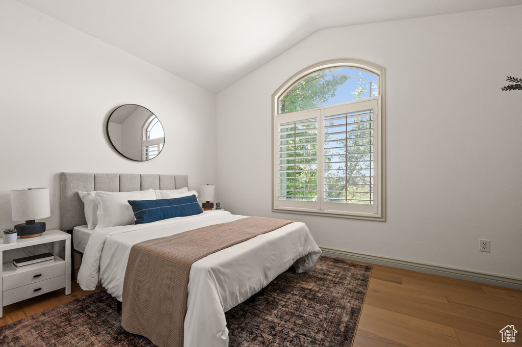 Bedroom featuring lofted ceiling and wood finished floors