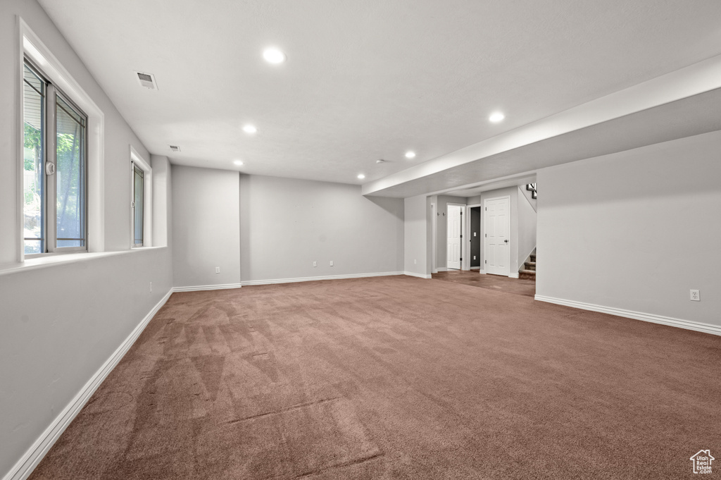 Below grade area with recessed lighting, carpet, and stairs