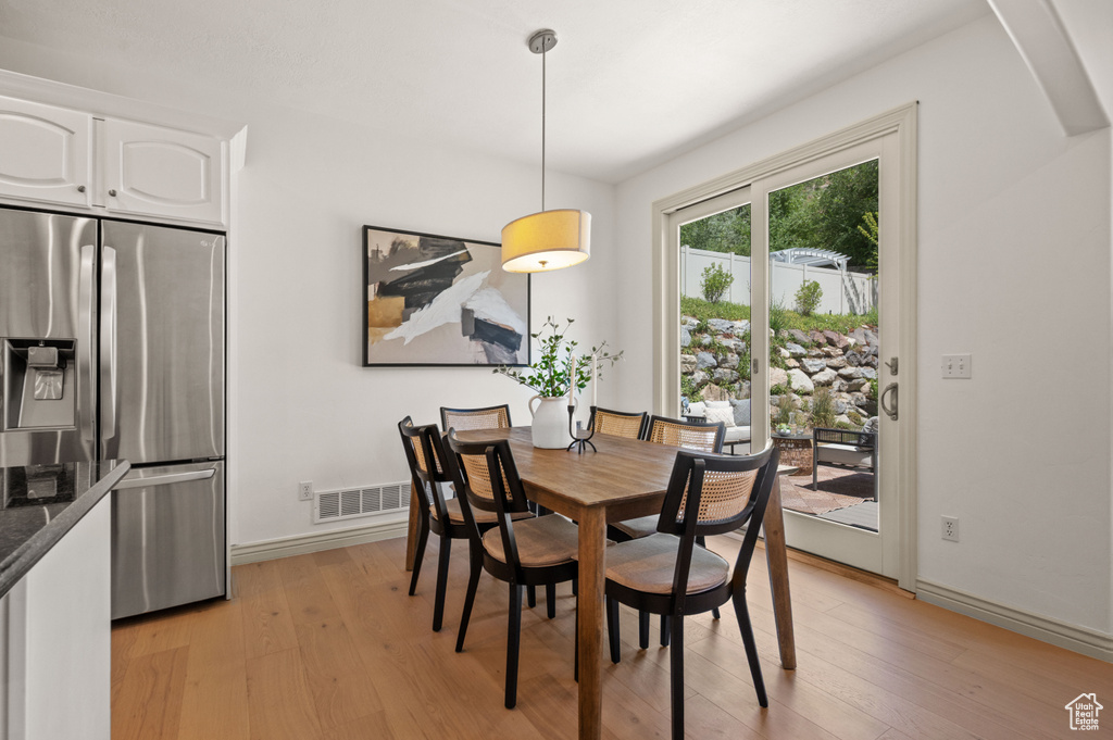 Dining space featuring light wood-style floors and arched walkways