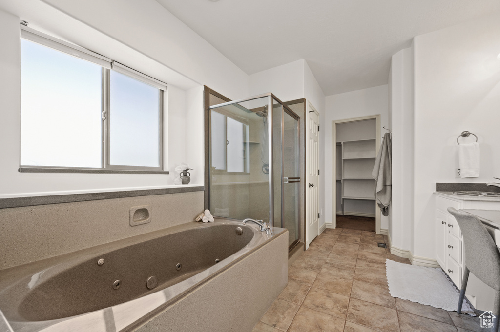 Bathroom featuring a stall shower, a whirlpool tub, vanity, and a closet