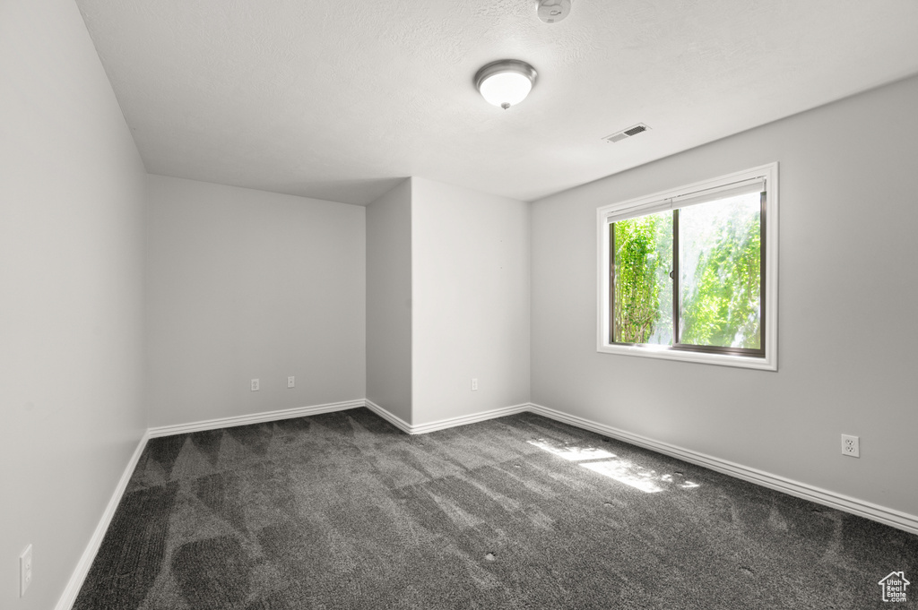 Carpeted empty room featuring baseboards