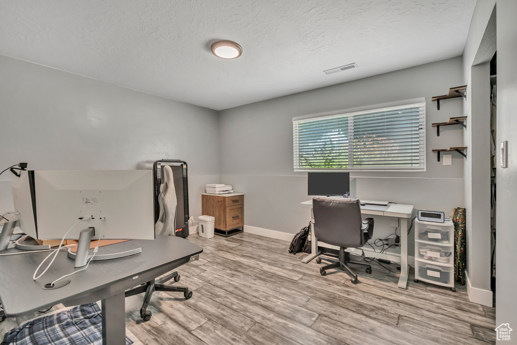 Home office featuring a textured ceiling and wood finished floors