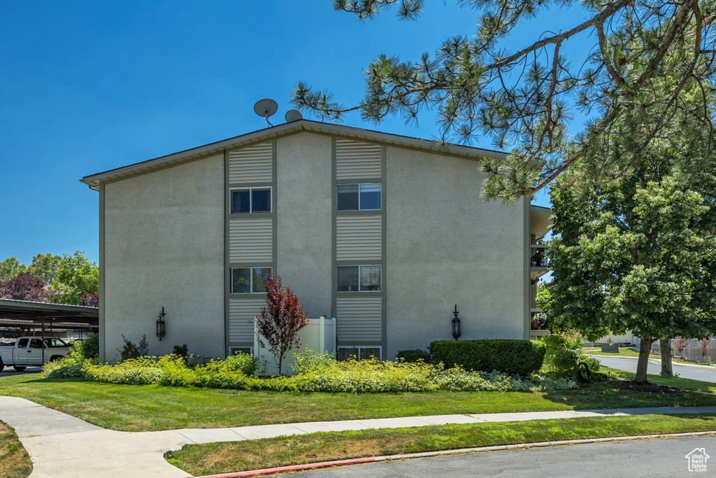 View of side of property featuring stucco siding and a lawn