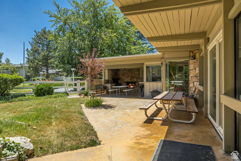 View of patio with a lit fireplace