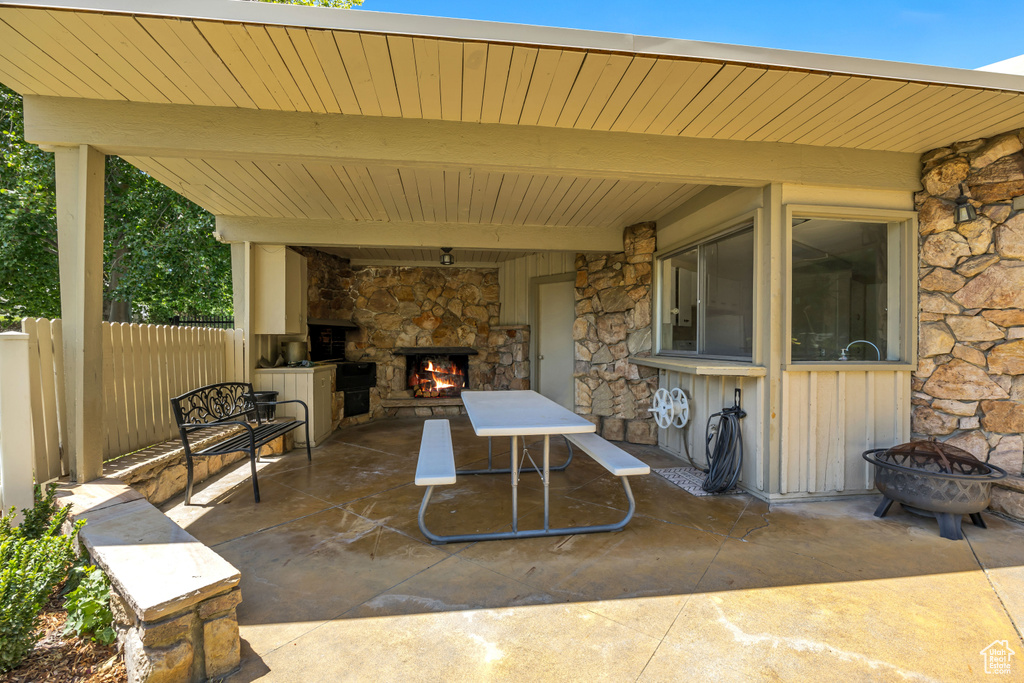 View of patio / terrace with an outdoor stone fireplace and a fire pit