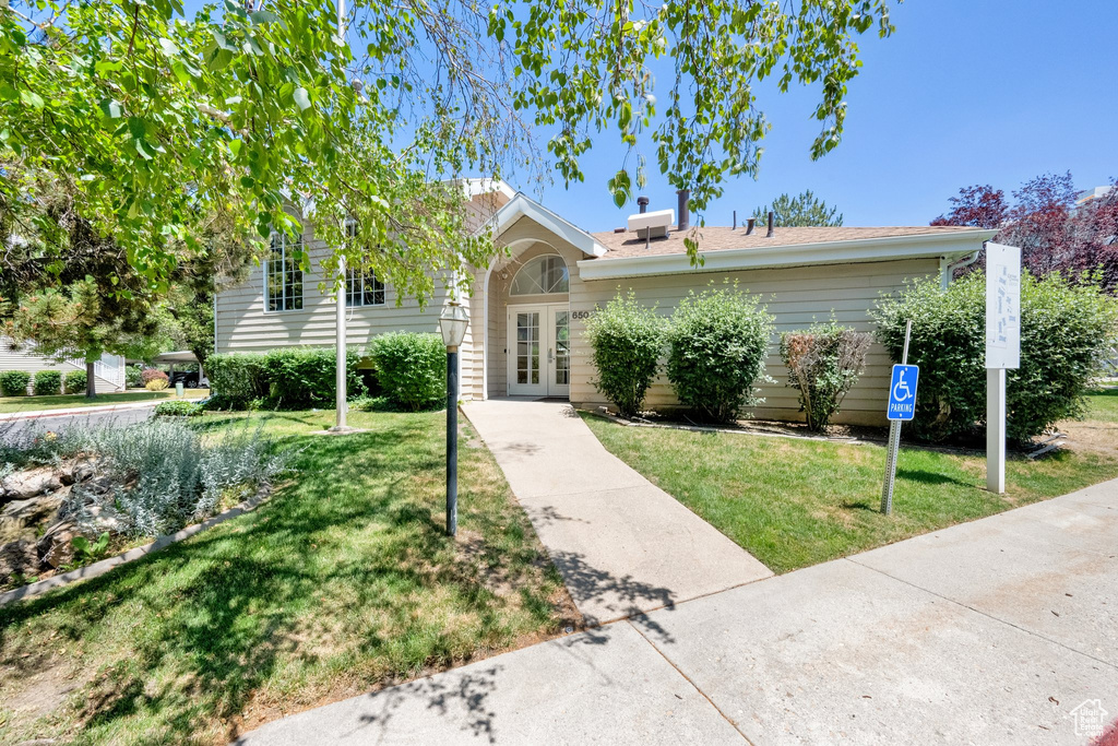 View of front of property with a front lawn and french doors