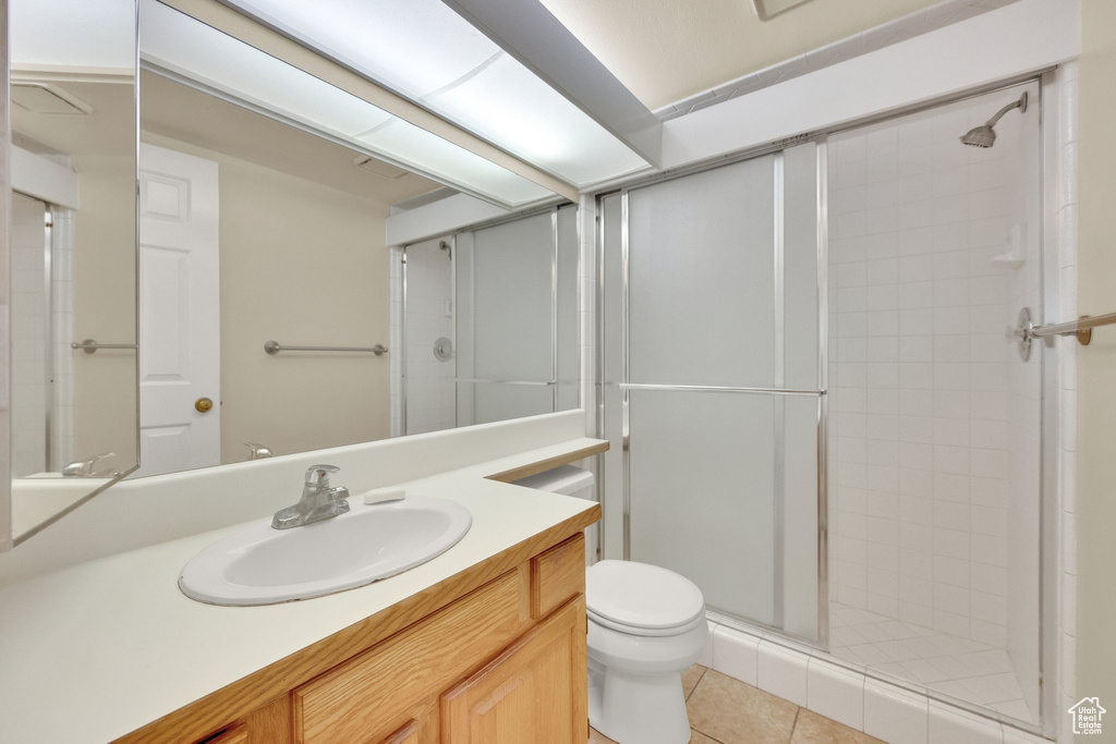 Bathroom with a stall shower, vanity, and tile patterned flooring