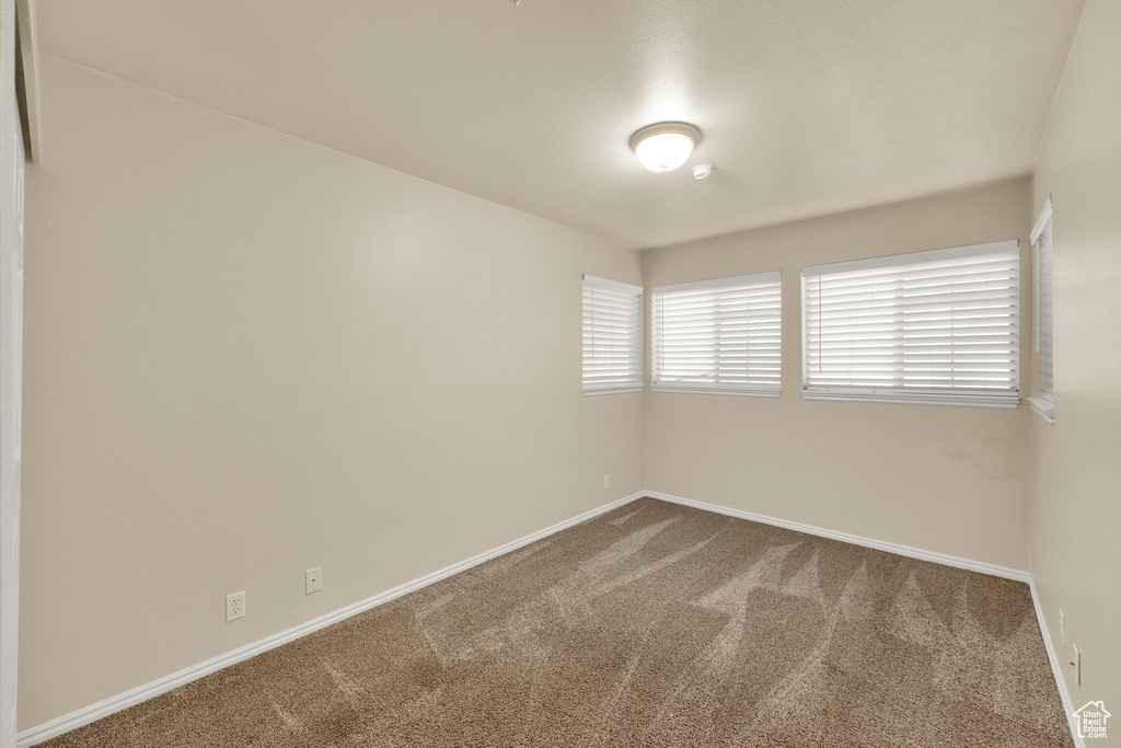 Carpeted spare room with baseboards