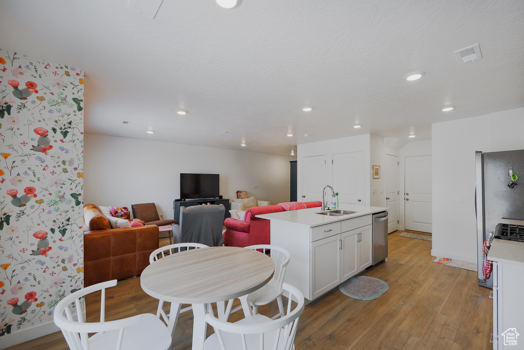 Dining space with light wood-style floors and recessed lighting