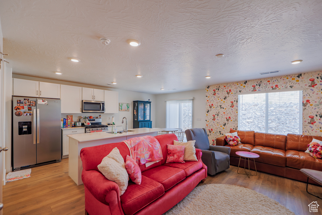 Living area featuring light wood-style floors and recessed lighting