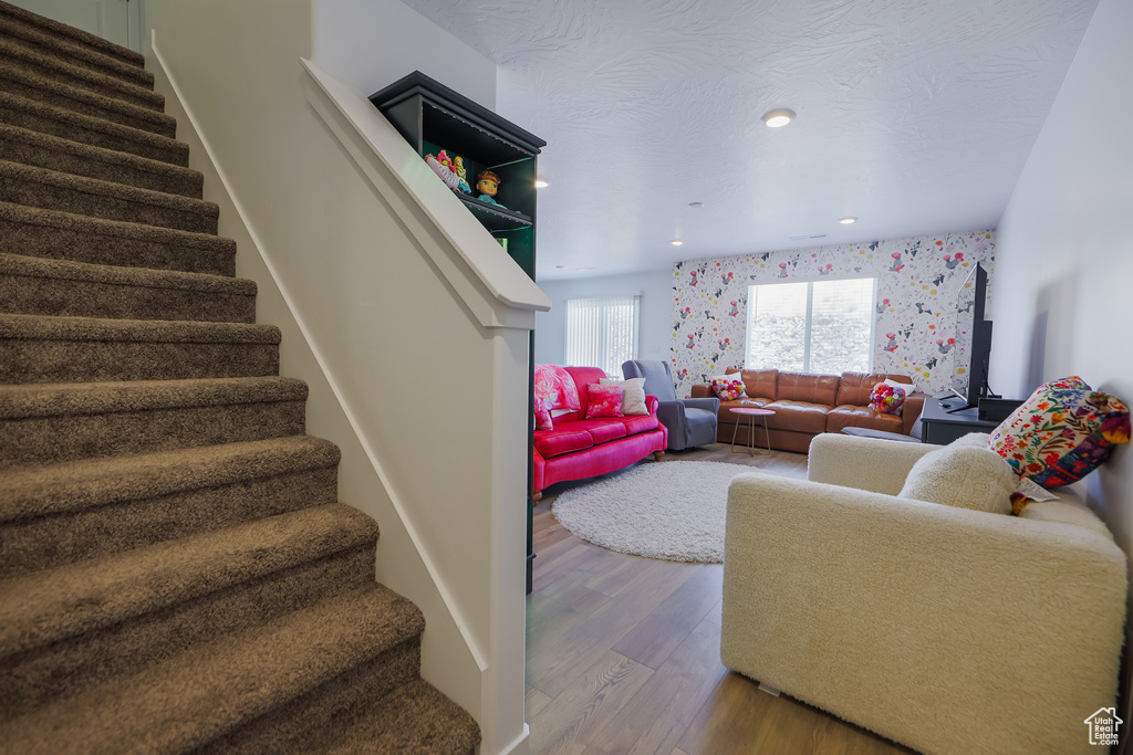 Living room featuring stairs, wood finished floors, and recessed lighting