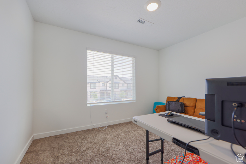 Carpeted office space with baseboards