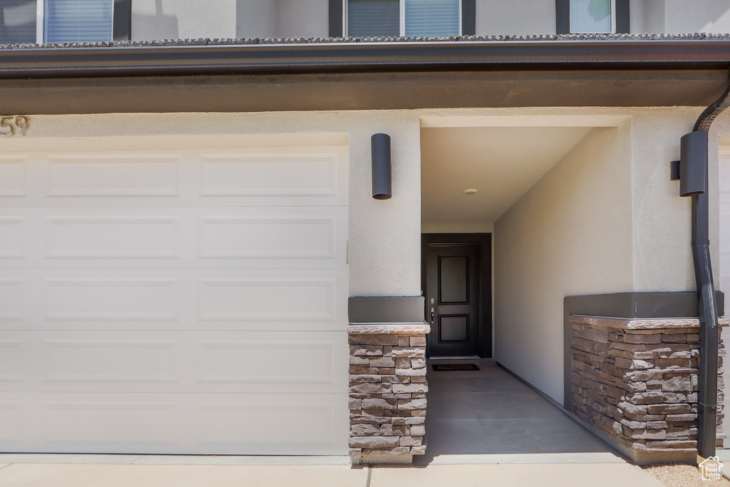 Doorway to property with stucco siding and stone siding