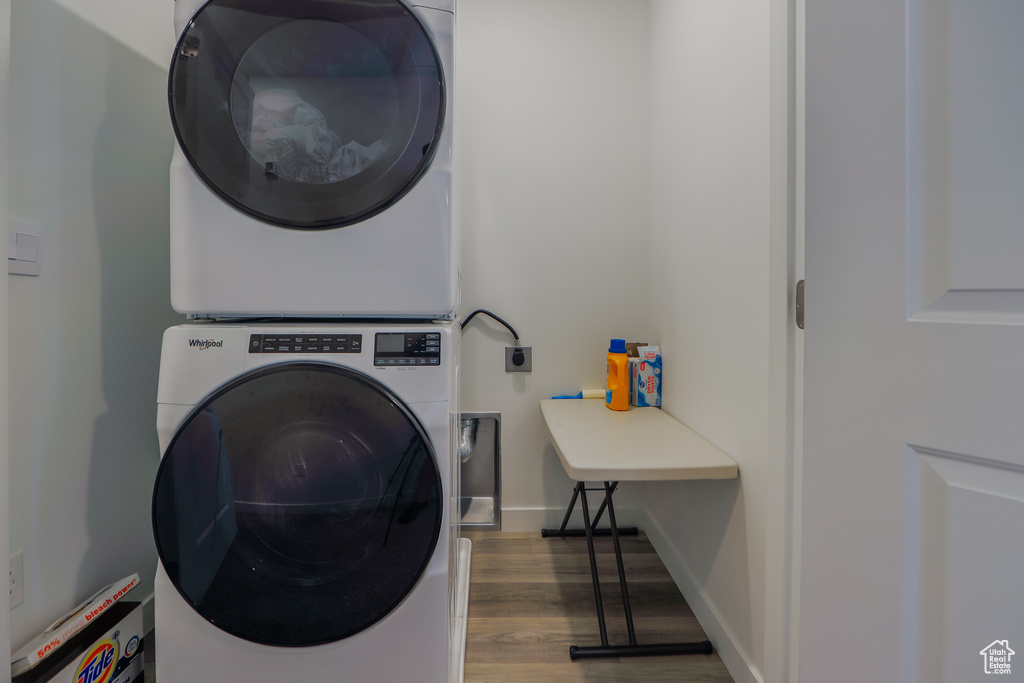 Laundry room with estacked washer and dryer and wood finished floors