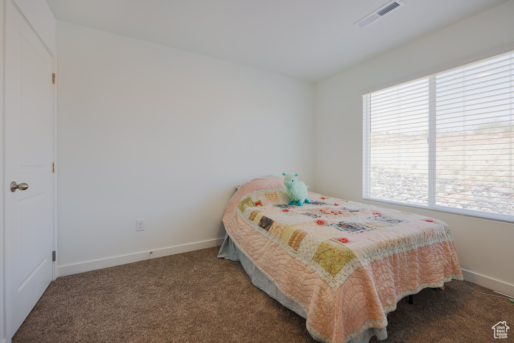 Bedroom featuring carpet and baseboards