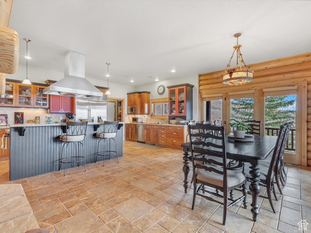 Dining space featuring stone tile floors and recessed lighting