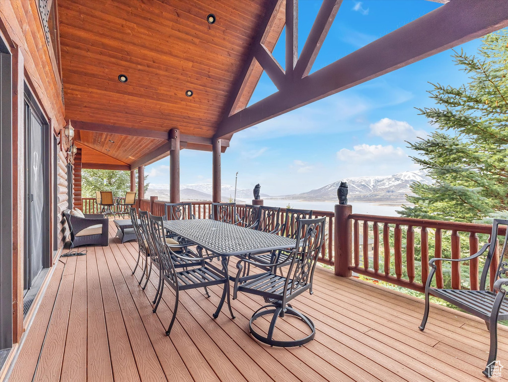 Wooden deck with a mountain view and outdoor dining area